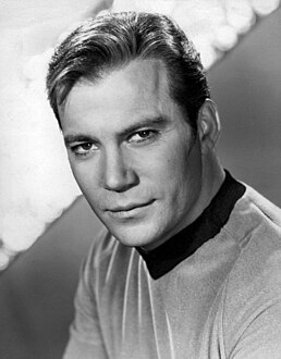 A black-and-white publicity portrait of Captain Kirk (actor William Shatner) in his Starfleet uniform.