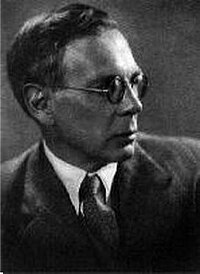 Black-and-white portrait photograph of a man from the chest up, wearing round wire-frame glasses, a dark jacket, and a tie; placed in the lecture directly beneath the heading