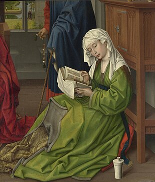 A woman in a green robe and white head covering kneels reading an open book, in a paneled interior room, with a partially visible figure in a blue robe and a red drape at the edge of the scene.